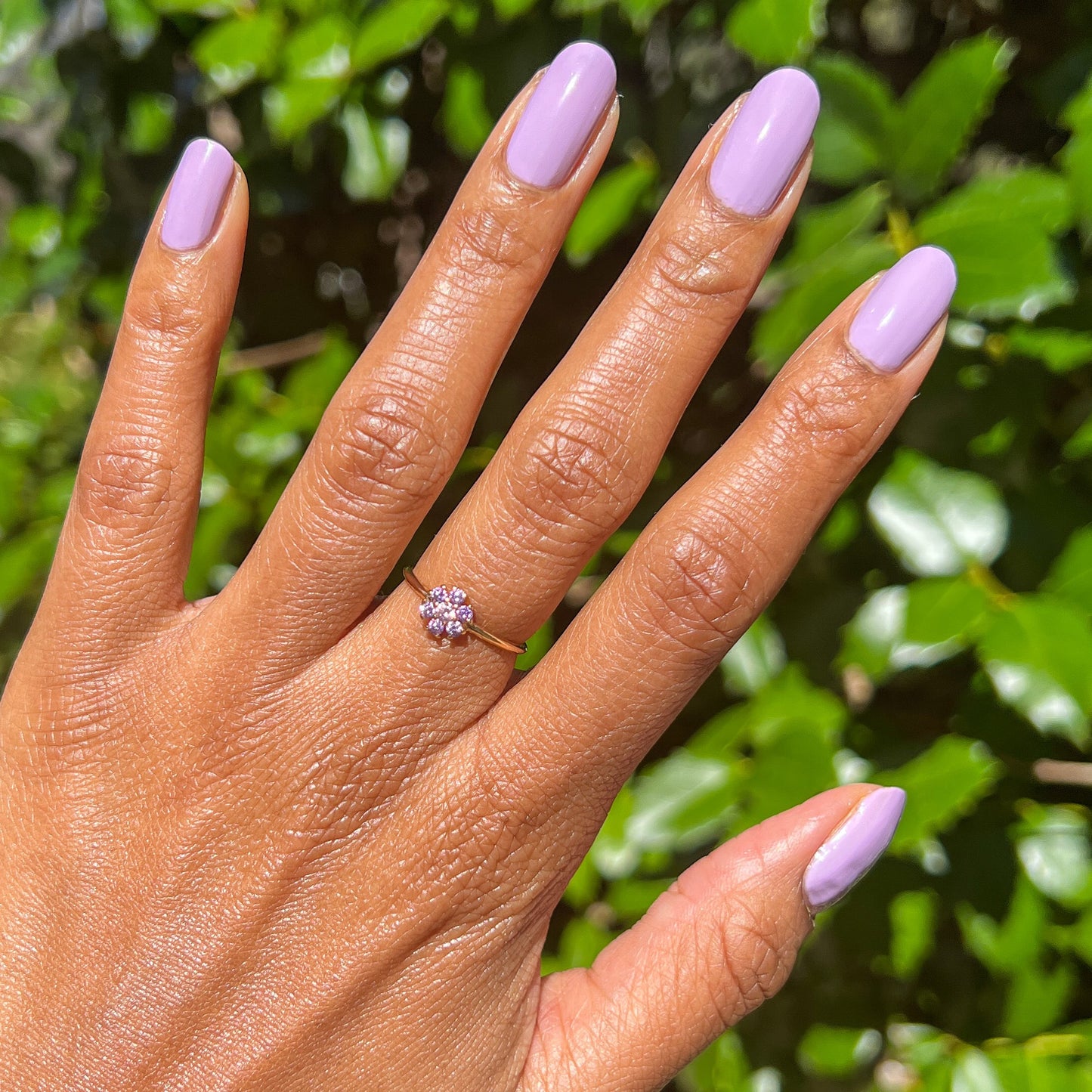 Hand with nails painted in playful lilac shade of You're Invited gel polish by Olive and June for a durable manicure