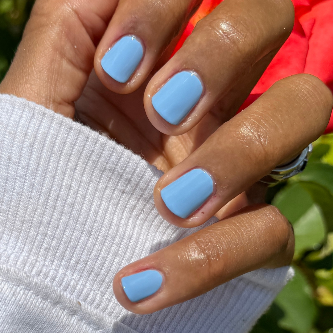Hand with smooth gel polish nails painted in Shades of Seersucker for a fresh, preppy summer manicure look
