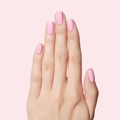 Hand with nails polished in bright bubbly pink SE by Olive and June for a fresh and sweet at-home mani look