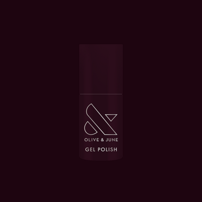 Bottle of Covet - Gel nail polish in a cool deep plum shade with Olive and June branding on dark background