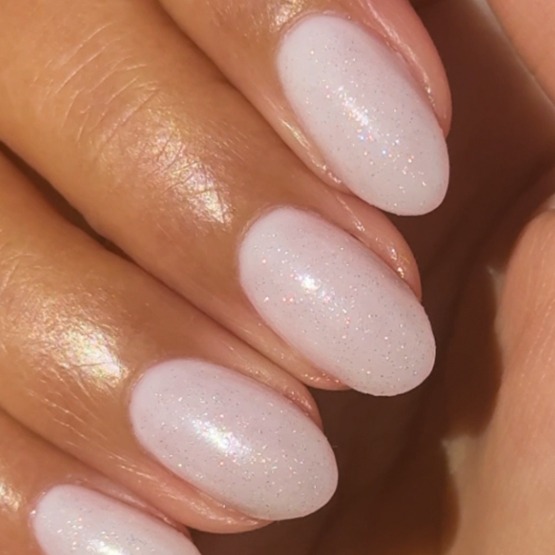The Celestial Effect Top Coat creating a soft white manicure with subtle sparkling micro-shimmer on natural nails