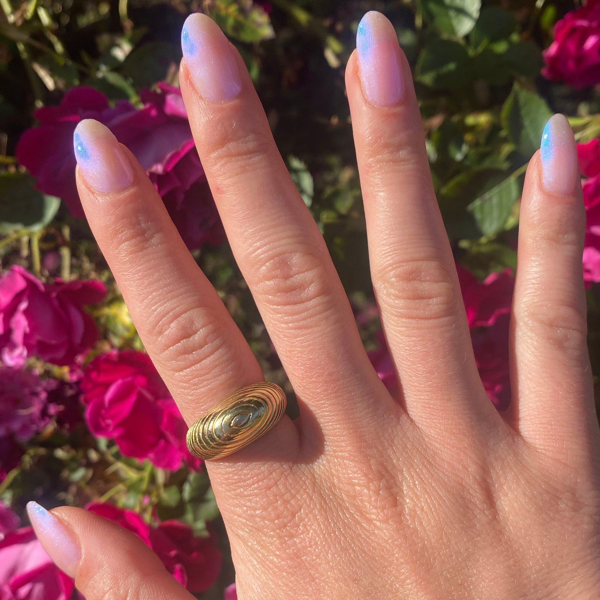 Natural nails with Pink Goldfish polish showing a soft iridescent manicure in sunlight for at-home mani by Olive and June