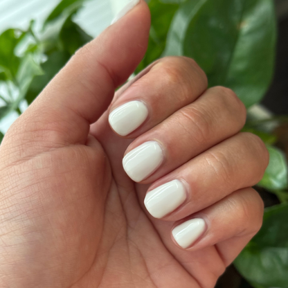 Hand with rounded nails painted in glossy soft white using LHG - Gel for a clean, polished mani look
