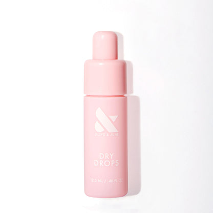Pink bottle of Olive and June Dry Drops with dropper cap for fast drying mani and polish care at home