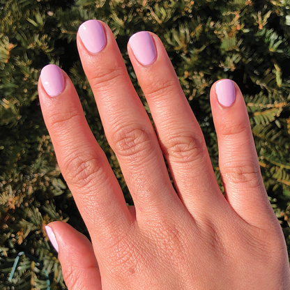 Hand with short nails painted in smooth Cockatoo polish by Olive and June for a gentle, long-lasting mani look