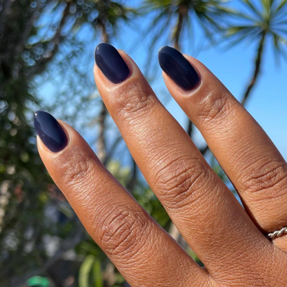 Suited - Gel dark sapphire gel polish manicure on medium-length almond-shaped nails outdoors with natural light