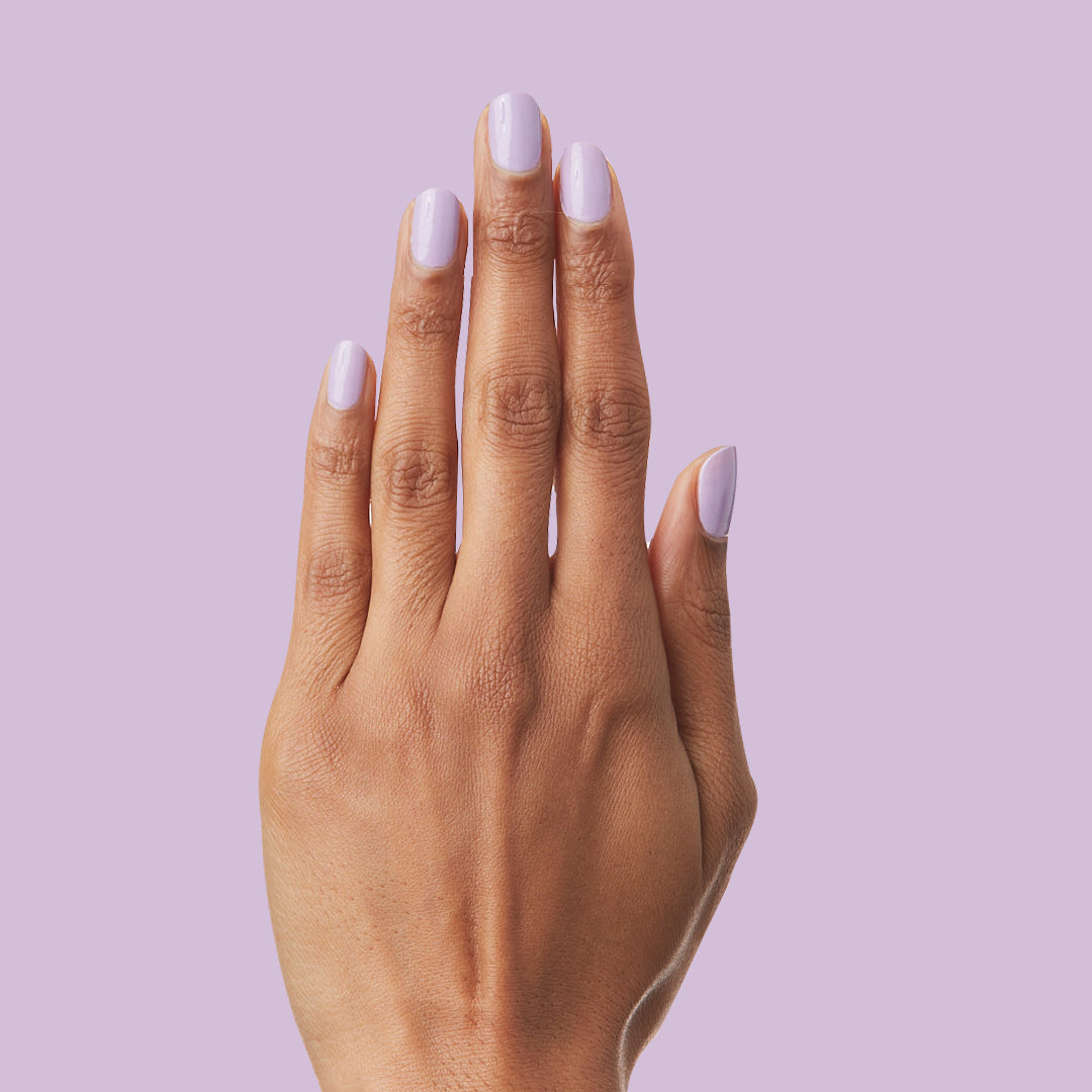 Hand with nails painted in soft lilac shade of You're Invited gel polish for a smooth, long-lasting manicure by Olive and June